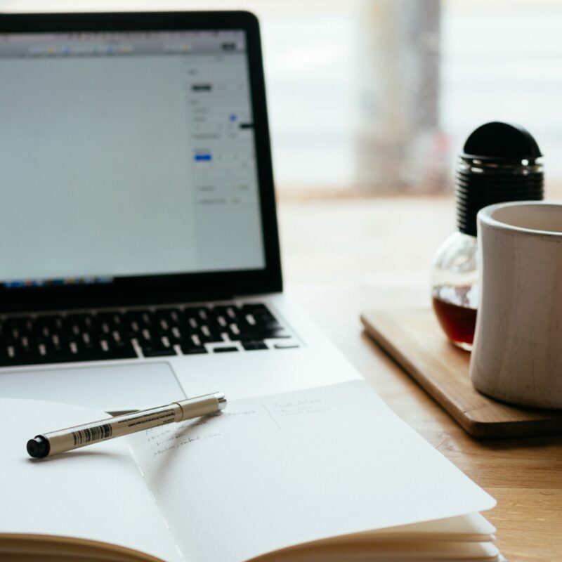 Laptop on desk with notepad